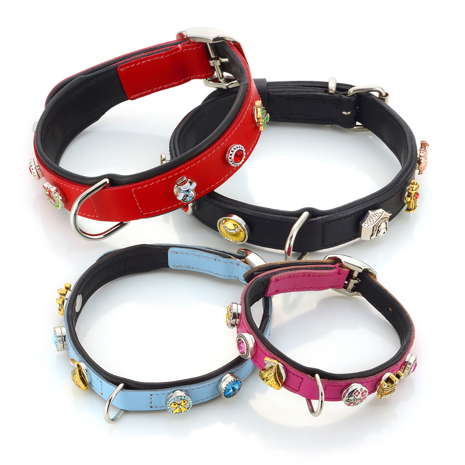 Styled product photo of four pet collars, one red, one black, one blue and one pink, all with decorative charms attached, all on white background Product Photography