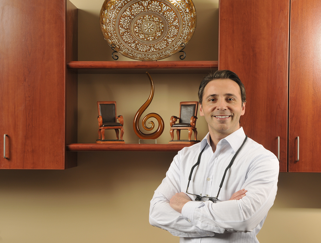 Dentist standing in front of ceramic display in front office