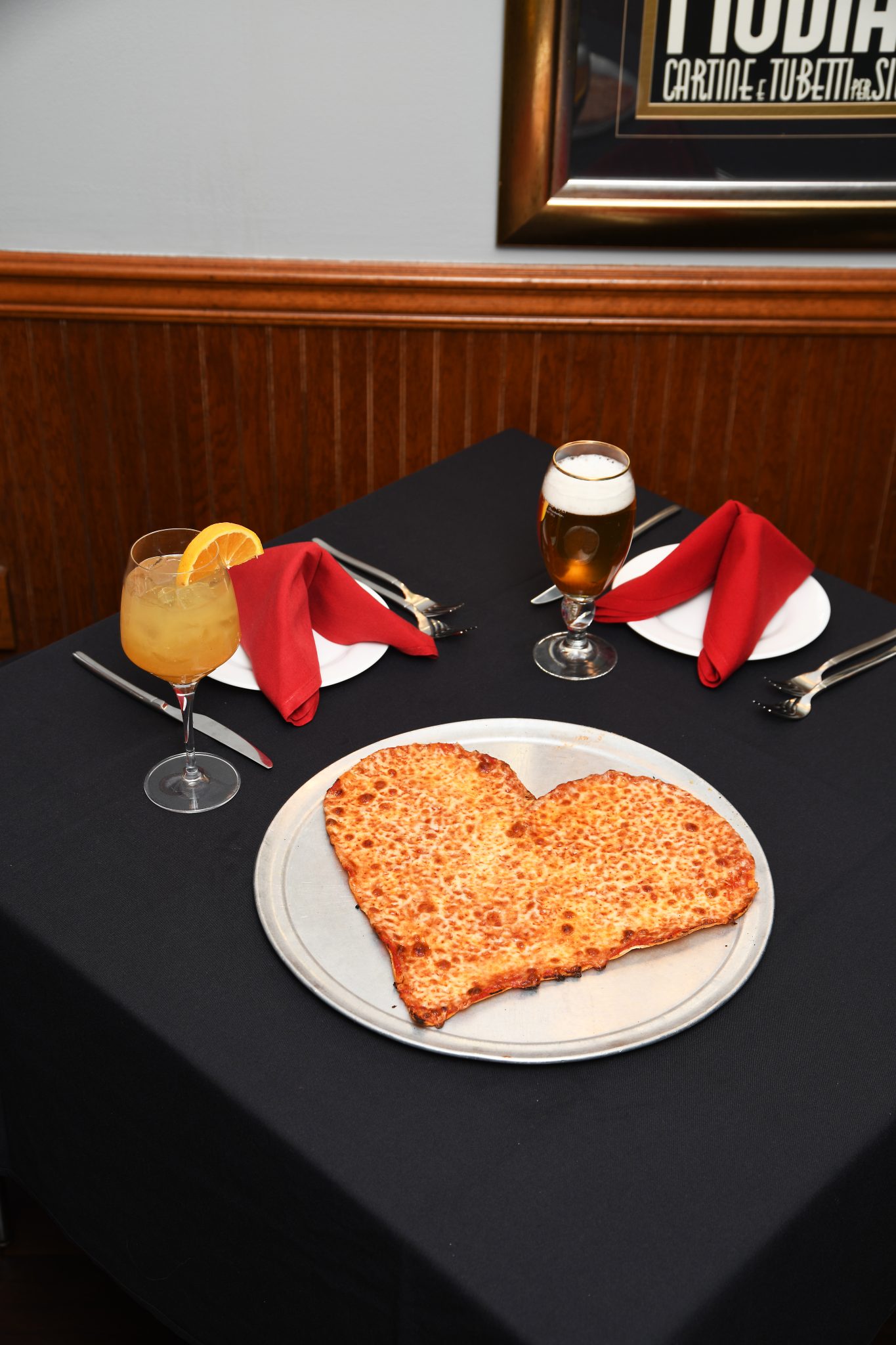 Heart Pizza on resturant table with drinks and plates